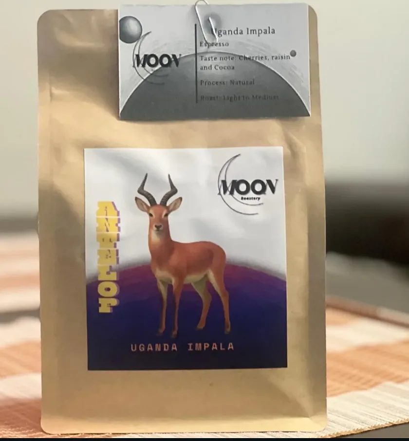 A sealed bag of Moon Roastery coffee with its spec card clipped to the top and the bean's label art printed on the front